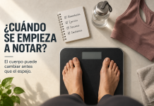 Cuándo se empieza a notar que estamos bajando de peso? Mujer sobre una balanza durante un proceso de cambio de hábitos, junto a elementos de alimentación, ejercicio y constancia.